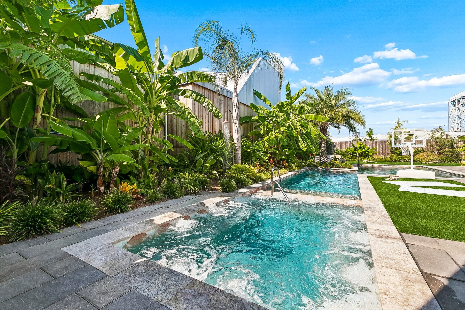The hot tub with the jets on, and the outdoor shower behind it