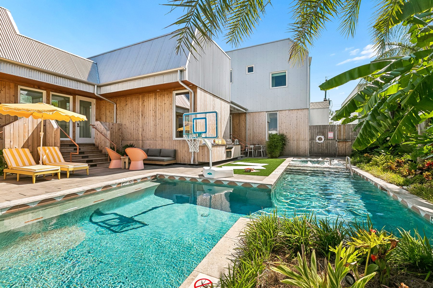 The pool basketball hoop, seen from across the pool, with loungers on the left