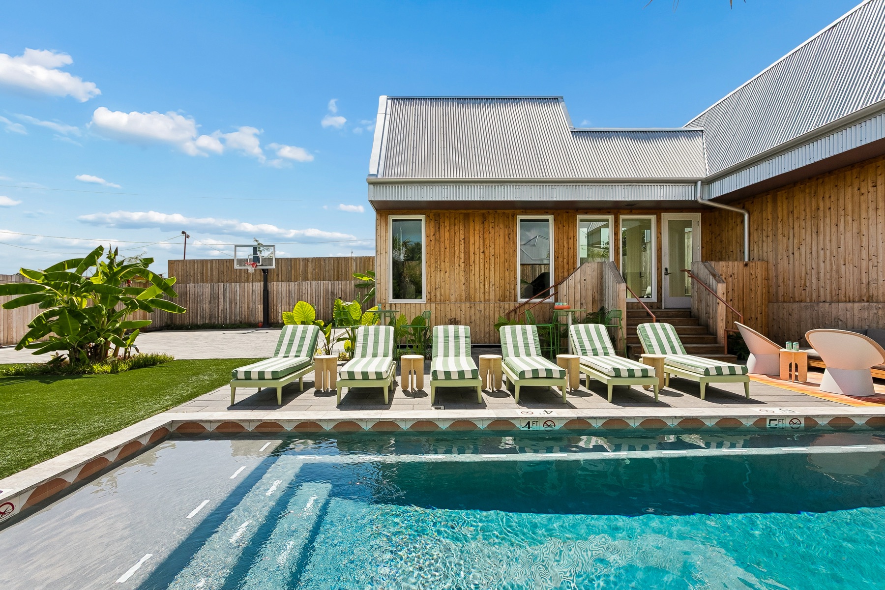 The heated pool and a row of striped loungers at the villa